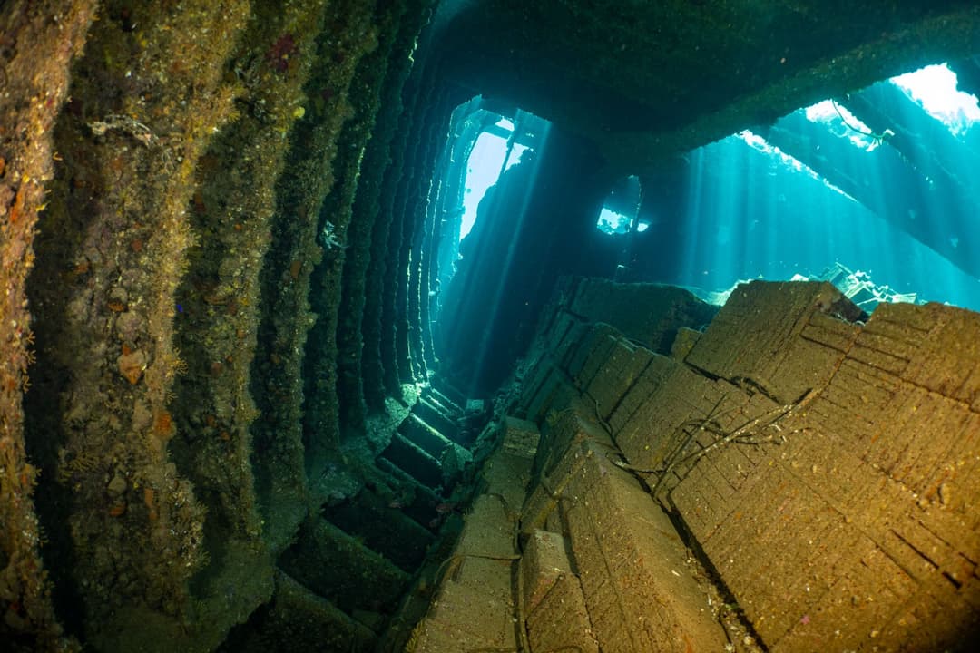 Taucher erkundet das Innere eines Wracks im Roten Meer