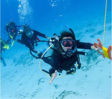 Drifttaucher schwimmen mit Signalboje im Roten Meer