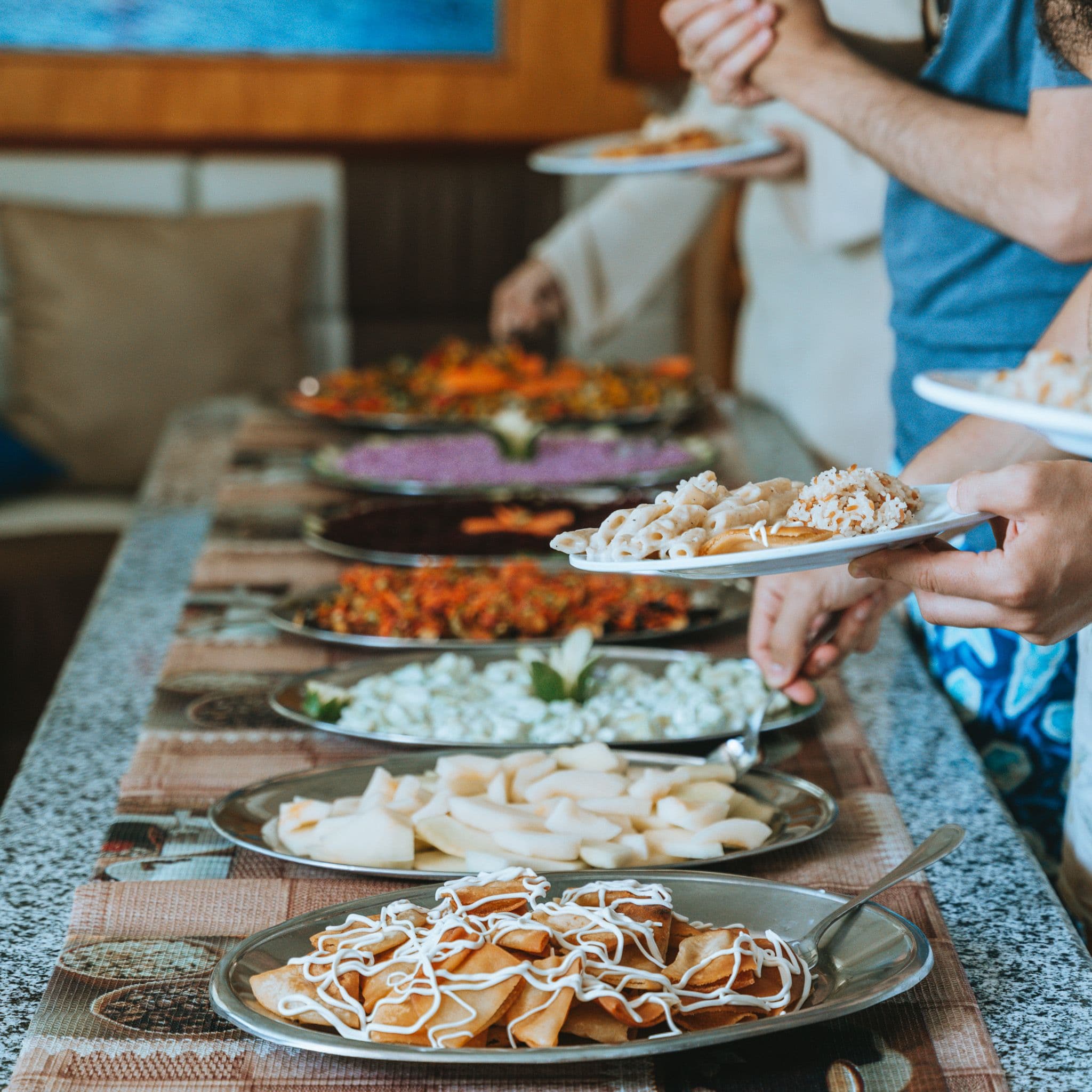 Gäste bedienen sich zwischen den Tauchgängen am Buffet auf dem Boot